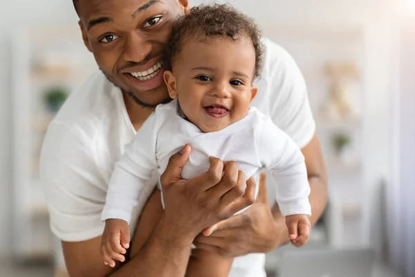 Close-up retrato de feliz afro-americano pai segurando adorável rindo bebê infantil — Fotografia de Stock