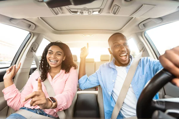 Glückliches schwarzes Paar genießt Musik am Steuer eines Luxusautos — Stockfoto