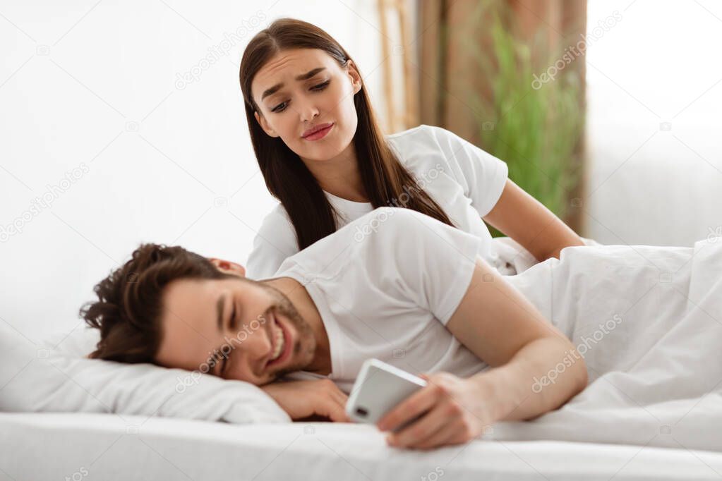 Jealous Wife Peeking At Husbands Phone Suspecting Affair Indoors