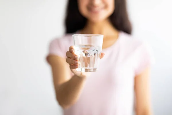Elinde kristal berrak su bardağı olan genç Hintli kadının kırpılmış görüntüsü, seçici odaklanma. — Stok fotoğraf