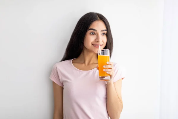 Wanita India yang bahagia memegang segelas jus buah, minum minuman menyegarkan di rumah. Detox, penurunan berat badan, konsep diet — Stok Foto