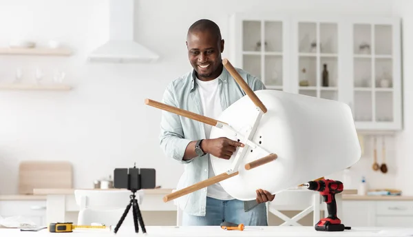 Blog sobre carpintería y reparaciones. Positivo Africano americano manitas mostrando acabado silla a smartphone webcam — Foto de Stock