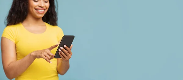 Neue mobile App oder cooles Angebot. Aufgeregte junge schwarze Frau mit Smartphone, blauem Hintergrund, leerem Raum — Stockfoto