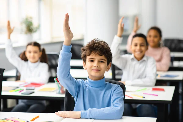 Kleine schoolkinderen hand in hand in de klas — Stockfoto