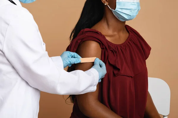 Обрізані руки медсестри кладуть групу для афроамериканської жінки — стокове фото