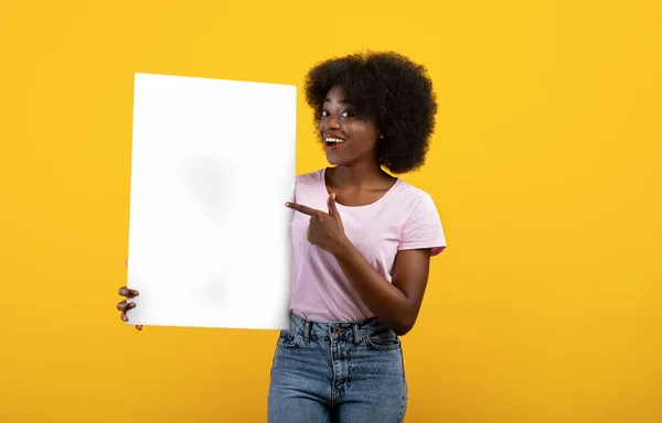 Lugar para el texto. Emocionada dama afroamericana señalando banner vacío con espacio para su diseño sobre fondo amarillo —  Fotos de Stock