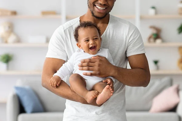 幸せな黒の父親の彼のかわいい笑いの赤ちゃんを保持している作物のショット — ストック写真