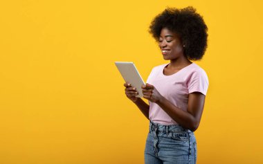 Teknoloji ve iletişim. Dijital tablet taşıyan mutlu siyah kadın, sarı arka plan, boş alan