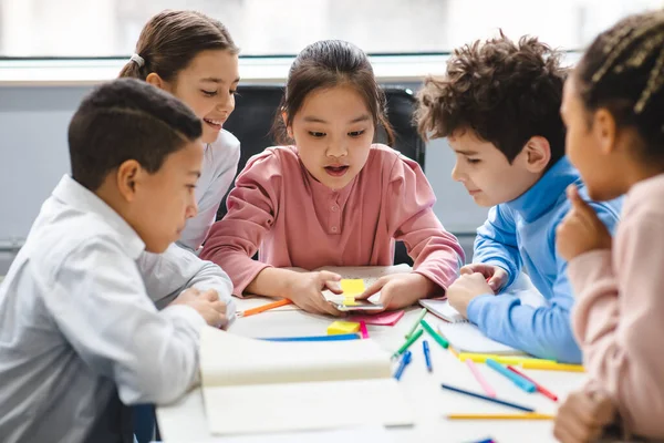 在课堂上使用移动电话的不同小学校学生 — 图库照片