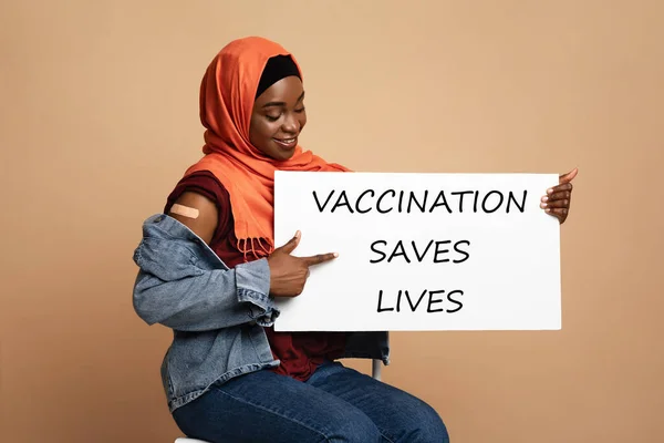 Black lady in hijab showing Vaccination Saves Lives placard — Stock Photo, Image