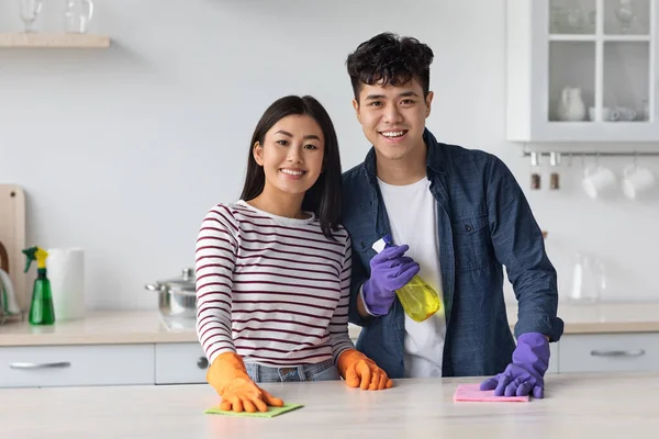 Χαρούμενη ασιατική ζευγάρι καθαρισμού κουζίνα στο νέο σπίτι — Φωτογραφία Αρχείου