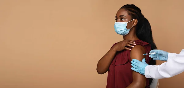 Visão lateral da mulher negra recebendo vacinação — Fotografia de Stock