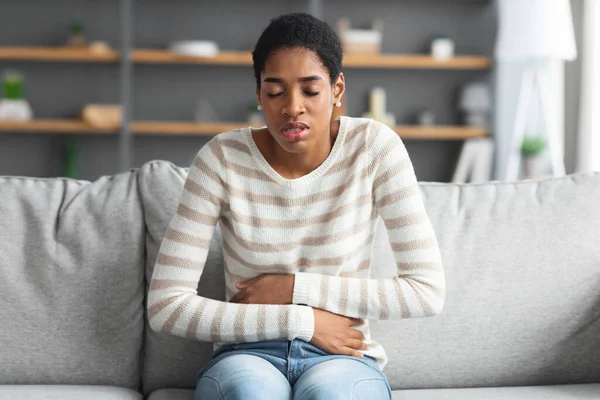 Magenschmerzen. Kranke schwarze Frau leidet zu Hause unter akuten Bauchschmerzen — Stockfoto