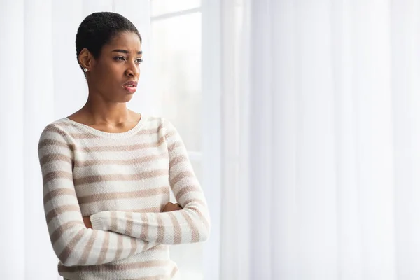 Κακή ιδέα της διάθεσης. Αναστατωμένη Αφρο-Αμερικανίδα κυρία στέκεται κοντά στο παράθυρο στο σπίτι — Φωτογραφία Αρχείου