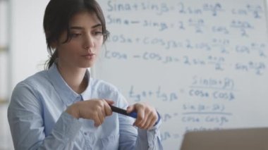 E-öğrenme konsepti. Genç profesyonel matematik öğretmeni öğrenciyle sohbet ediyor, matematik formüllerini anlatıyor.