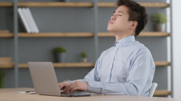 Giovane uomo asiatico manager digitando sul computer portatile e iniziare a meditare, tenendosi per mano nel gesto mudra — Video Stock