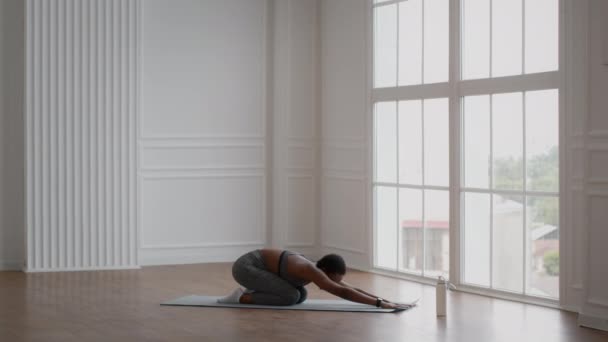 Deportiva joven afroamericana practicando yoga en la postura de los niños — Vídeos de Stock