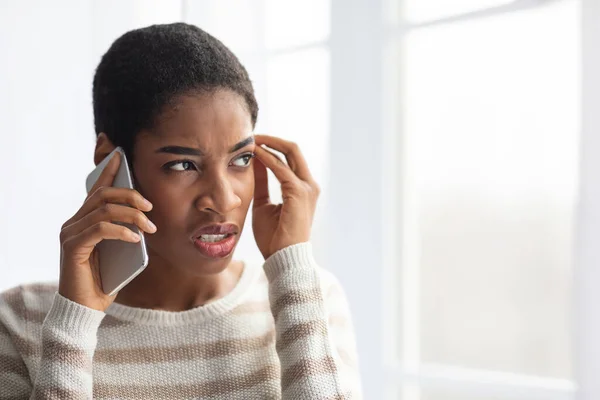 Afroamerikanerin leidet unter schlechter Verbindung, während sie zu Hause mit dem Handy spricht — Stockfoto