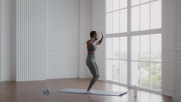 Desportivo afro-americano mulher realizando exercício burpee em casa, imagens de câmera lenta — Vídeo de Stock