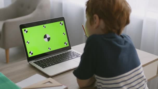 Internet para crianças. Rastreamento tiro de menino assistindo filme on-line no laptop com tela de chave de croma verde — Vídeo de Stock