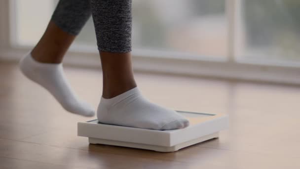 Femme afro-américaine méconnaissable marchant sur des écailles, vérifiant son poids, gros plan — Video