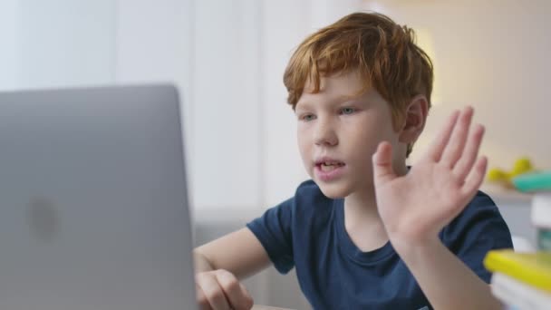 Grabben i den digitala världen. Närbild porträtt av liten rödhårig pojke skriva på laptop, videochattar online hemma — Stockvideo