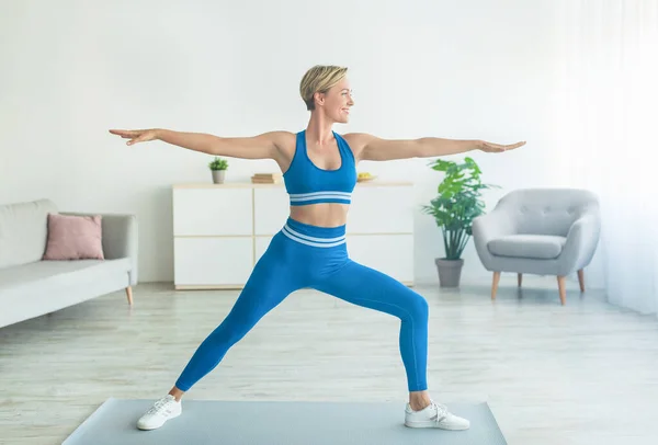 Leende ateltisk kvinna stående i 2 krigare II Pose — Stockfoto