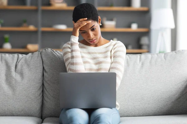 Στρεσαρισμένη Αφροαμερικανή γυναίκα κοιτάζοντας οθόνη φορητού υπολογιστή στο σπίτι — Φωτογραφία Αρχείου