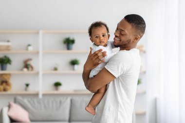 Baba ve Bebek. Mutlu Siyah Baba 'nın Portresi Sevimli Bebek Tutuyor