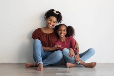 Evde yerde poz veren sevecen siyahi aile