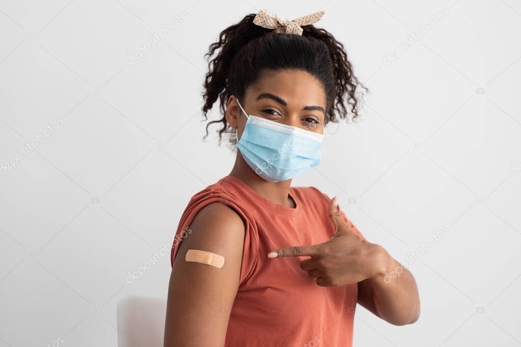 African american woman with face mask posing after immunization, closeup