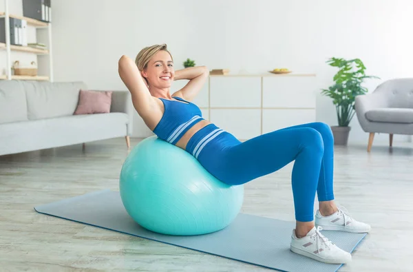 Smiling Sporty Woman Exercising Leaning On Ball At Home — Stock Photo, Image