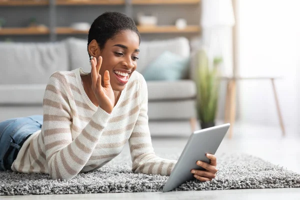 Positiv svart dam med digital surfplatta gör videosamtal hemma — Stockfoto