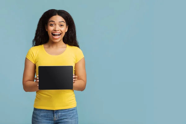 Femme afro-américaine ravie montrant tablette numérique avec écran noir, démontrant l'espace pour la conception de maquettes — Photo