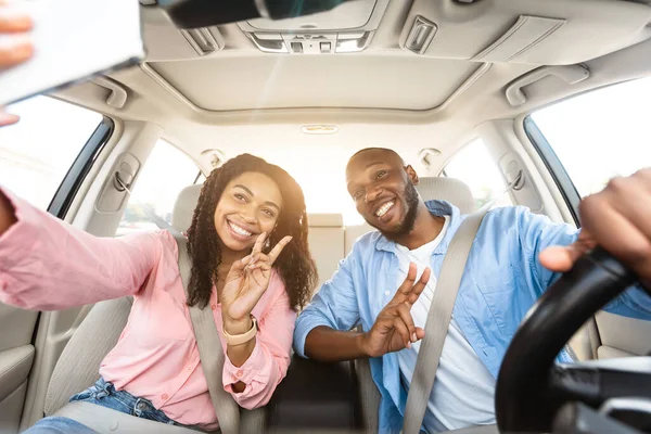 Feliz pareja negra conduciendo coche y tomando selfie —  Fotos de Stock
