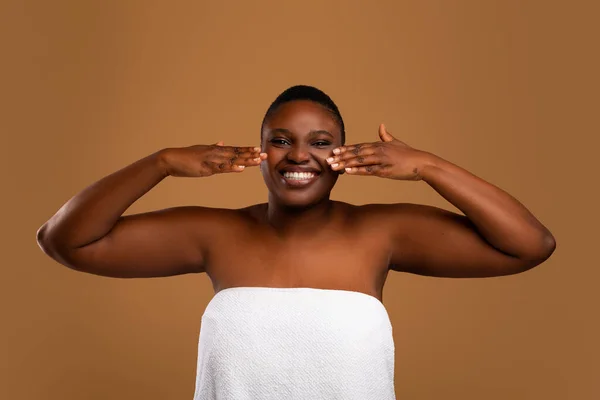Mooi jong Afrikaans amerikaans vrouw aanbrengen gezicht moisturizer — Stockfoto
