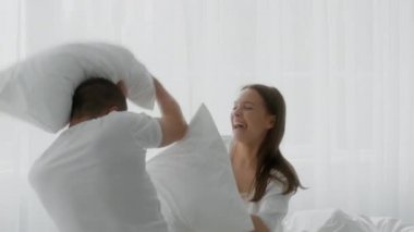 Mutlu genç çift yatak odasında kavga ediyor, evde eğleniyorlar.