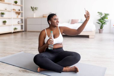 Ayrıca ev eğitimine ara verip selfie çeken boyunda siyahi bir kadın. İnternette kişisel koçla görüntülü konuşma.