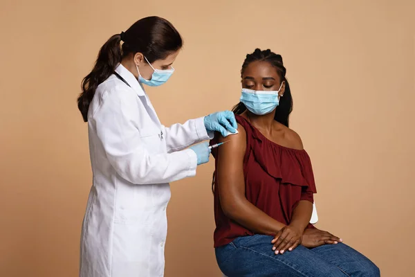 Чорна леді пацієнт в масці для обличчя отримує вакцинацію — стокове фото