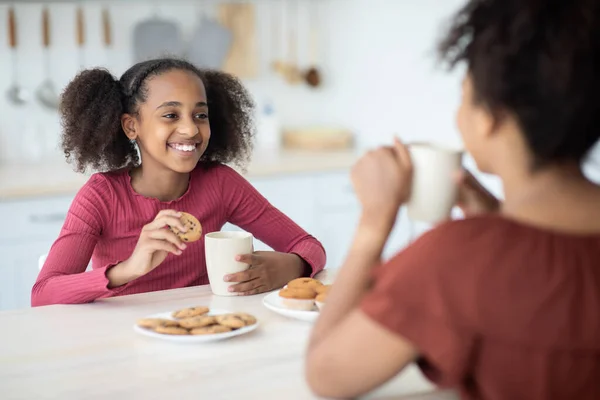 สาวแอฟริกันอเมริกันน่ารัก ดื่มชากับแม่ของเธอ — ภาพถ่ายสต็อก