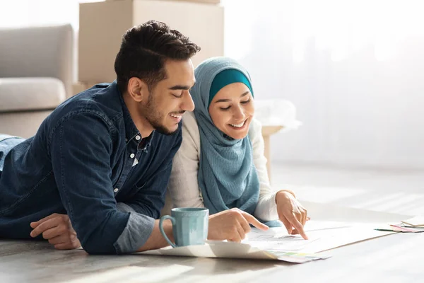 Famiglia musulmana creativa posa sul pavimento con schema appartamento — Foto Stock