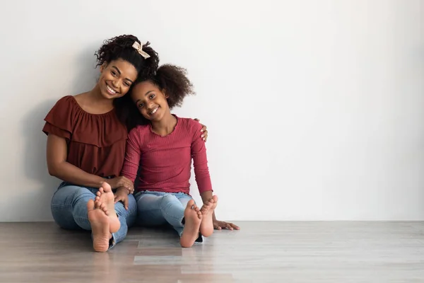 Adorable madre afroamericana y hija sentadas juntas en el suelo — Foto de Stock