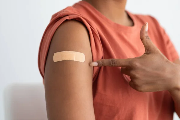 Paciente irreconocible apuntando a la banda medial en su brazo —  Fotos de Stock