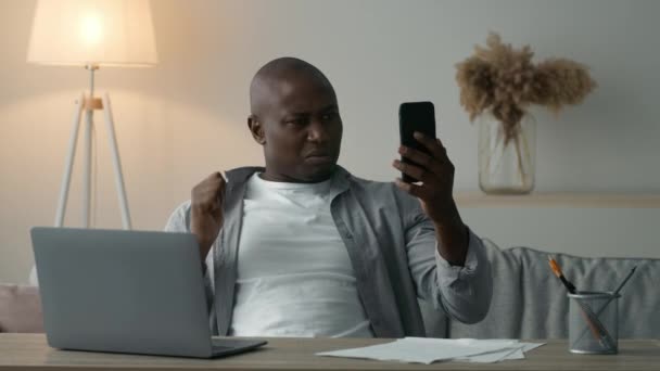 Nespokojený černoch video volání emocionálně do smartphonu vnitřní — Stock video