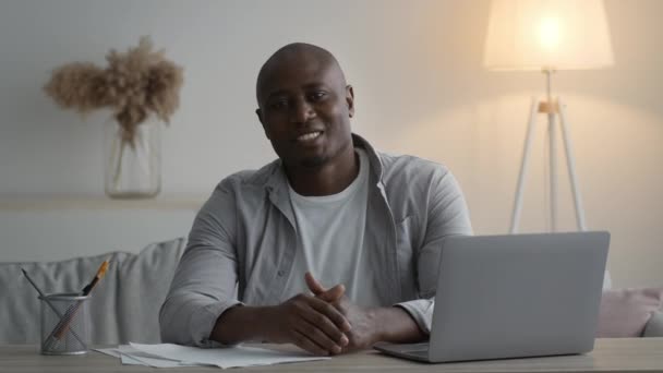 Negro hombre hablando buscando a cámara teniendo video llamada interior — Vídeo de stock