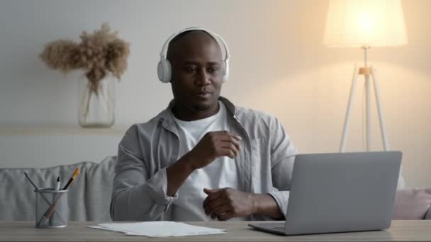 Afro-Amerikaanse man luisteren muziek dragen koptelefoon dansen op het werk — Stockvideo