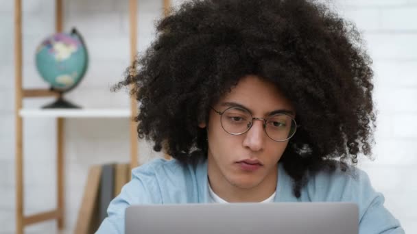 Trött student Guy lära sig att använda laptop bär glasögon inomhus — Stockvideo