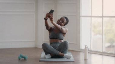 Neşeli Afrikalı Amerikalı kadın evde eğitim görürken Smartphone 'da selfie çekiyor