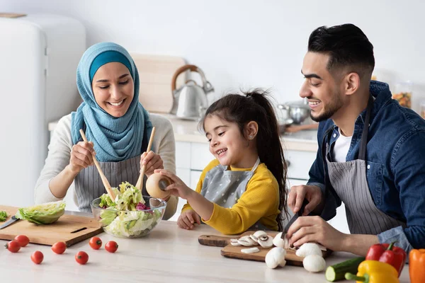 Sağlıklı öğle yemeği. Mutfakta üç kişilik neşeli Müslüman Aile Sebze Yemekleri — Stok fotoğraf