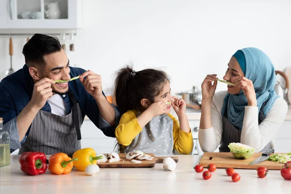 Arap baba, anne ve küçük kız mutfakta marulla bıyık yapıyorlar. — Stok fotoğraf